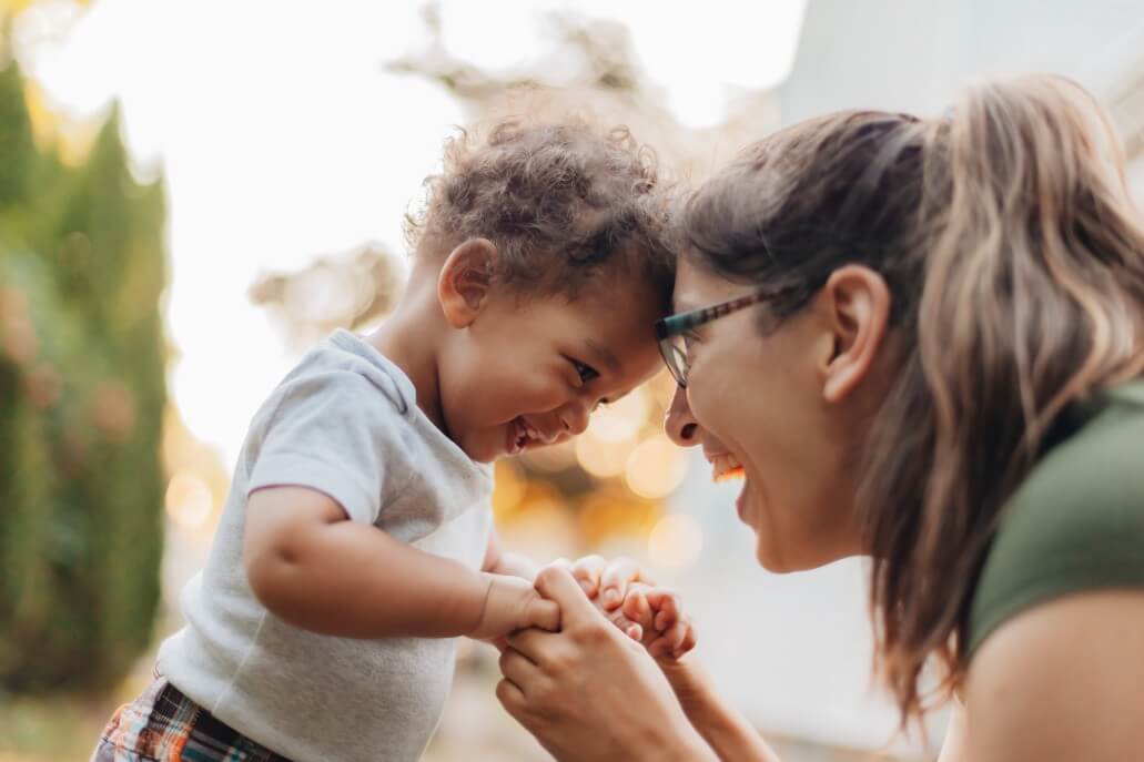 A candid moment with a mother and infant son touching foreheads