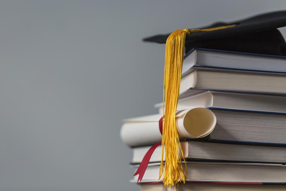 Graduation cap on top of stack of books