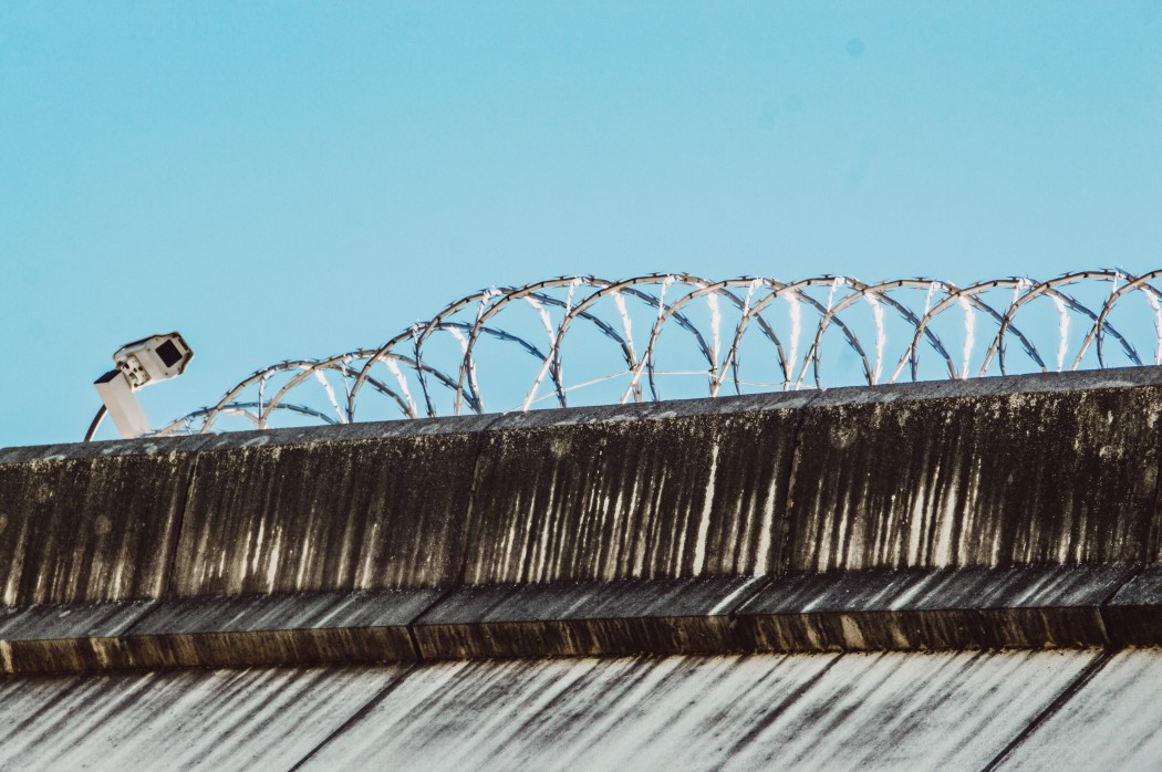 Security camera on fence with barbed wire