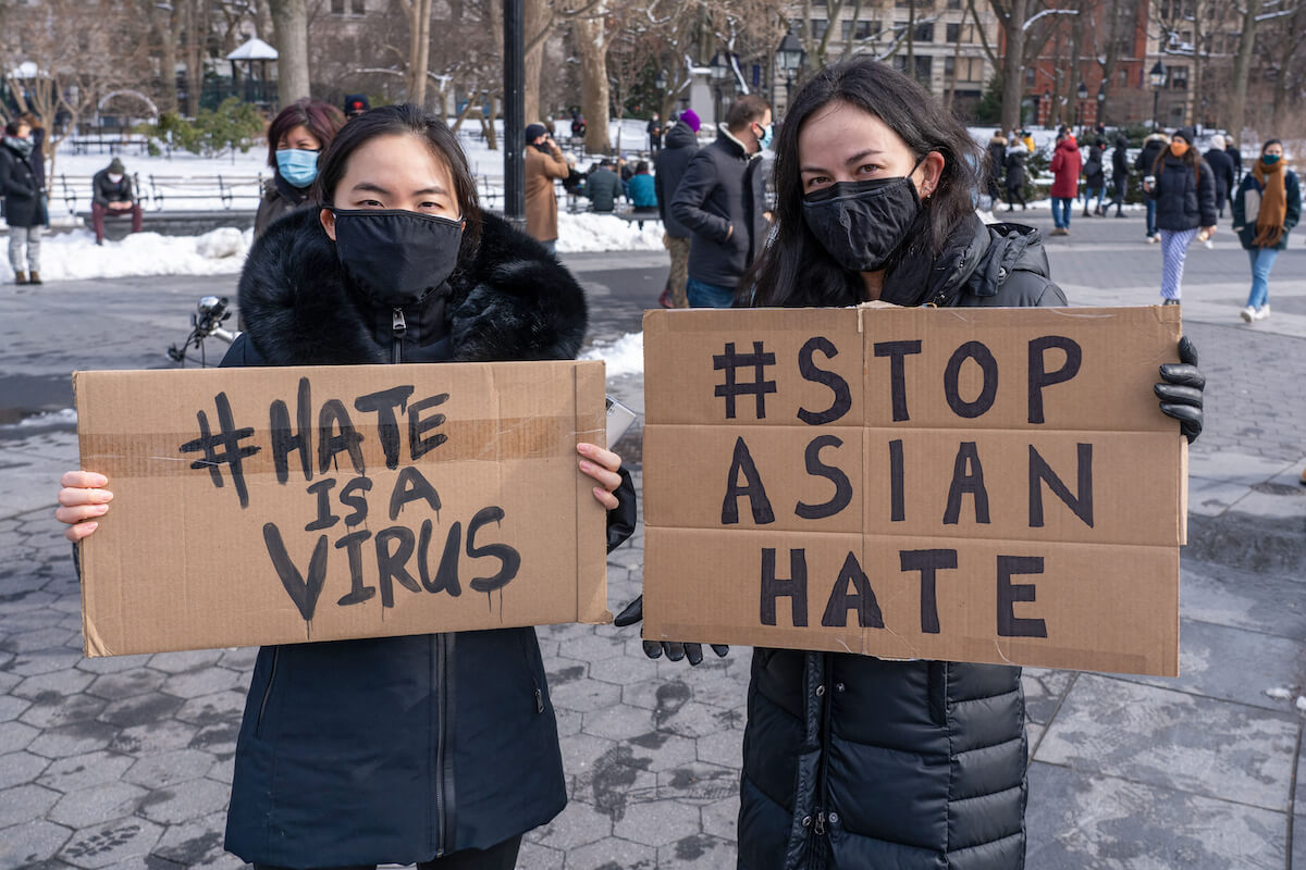 Protestors in New York City hold signs reading "Hate Is A Virus" and "Stop Asian Hate"