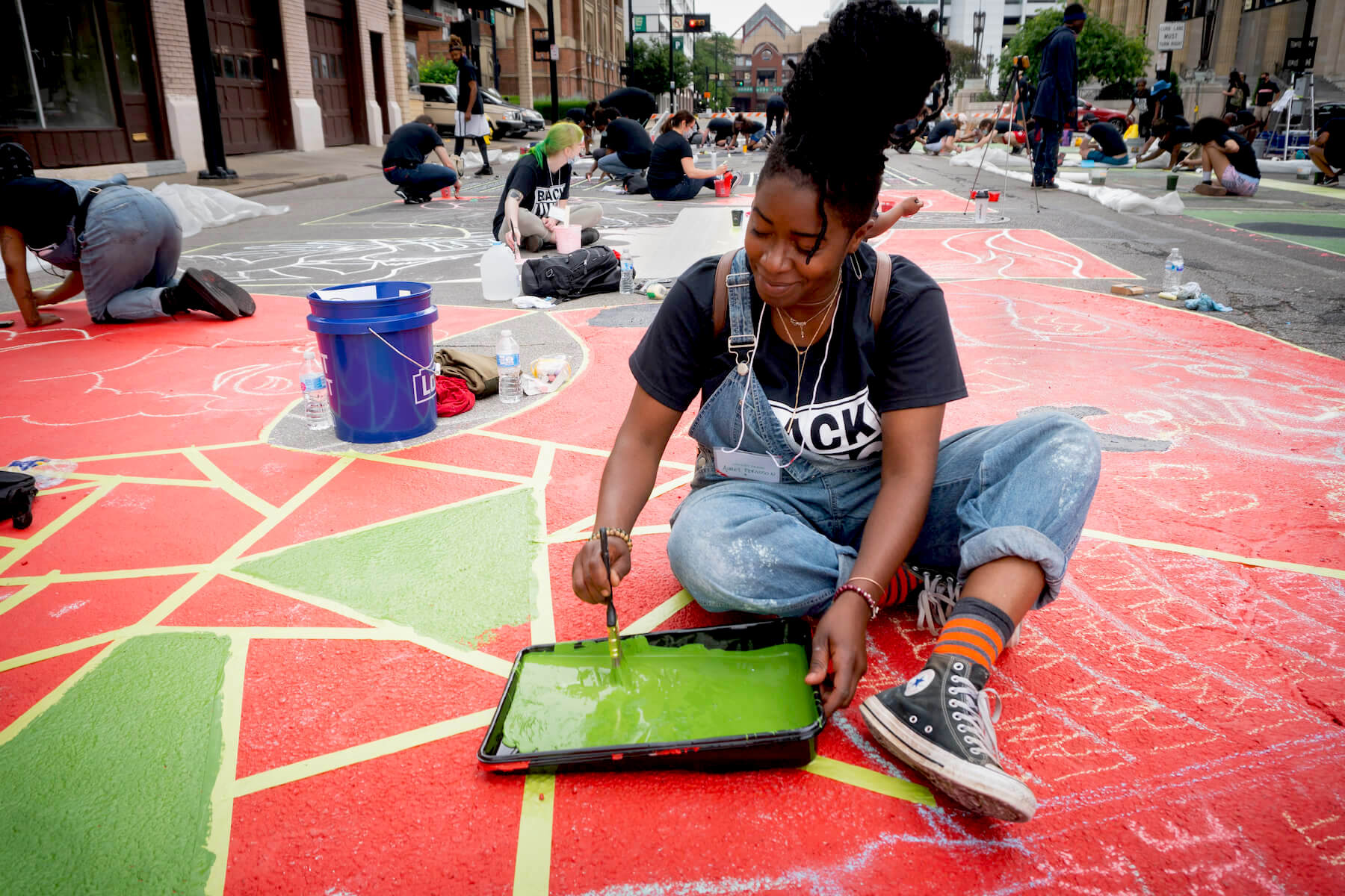 Mural Artists collectively create street art in front of City Hall