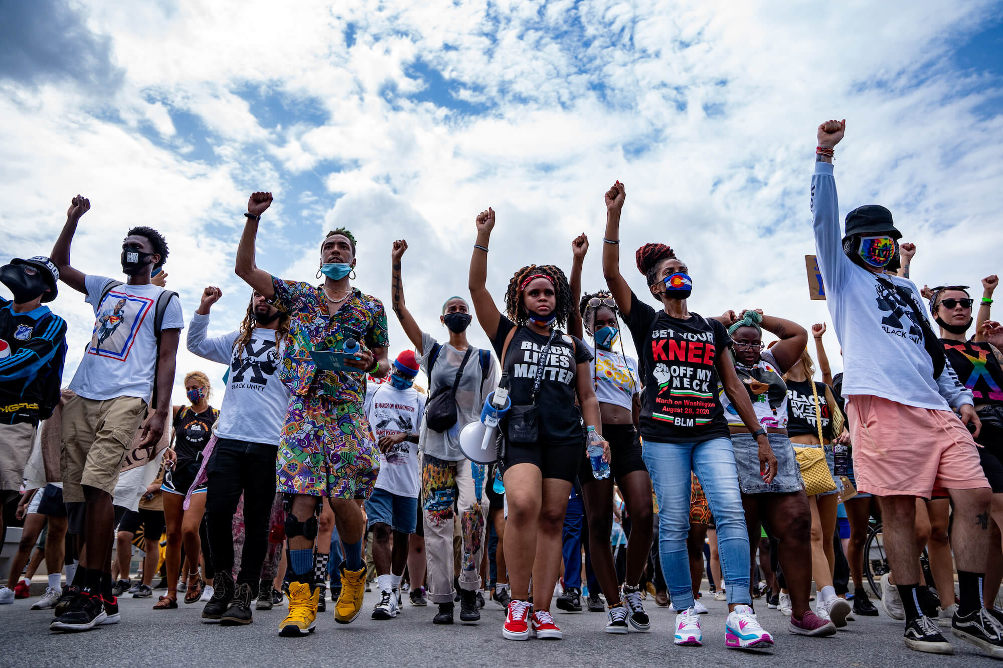Line of protesters marching holding their fists up for Black Lives Matter