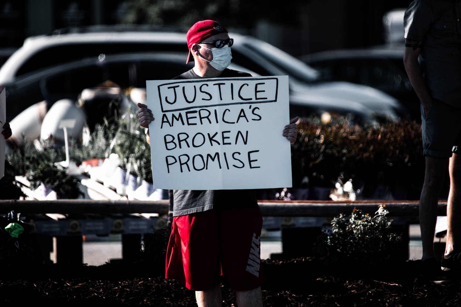Protester in Omaha, Nebraska protests the killing of George Floyd; sign reads "Justice: America's Broken Promise"