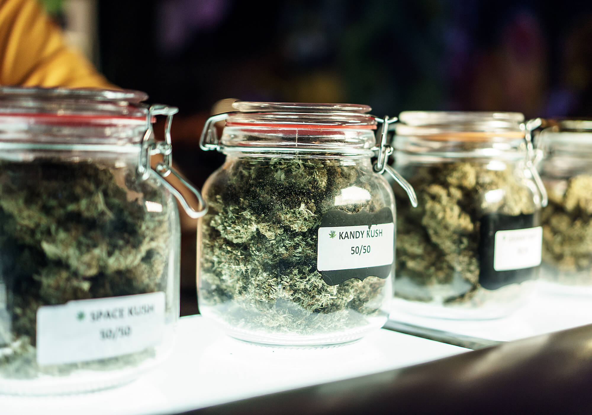 A dispensary worker vending jars of cannabis