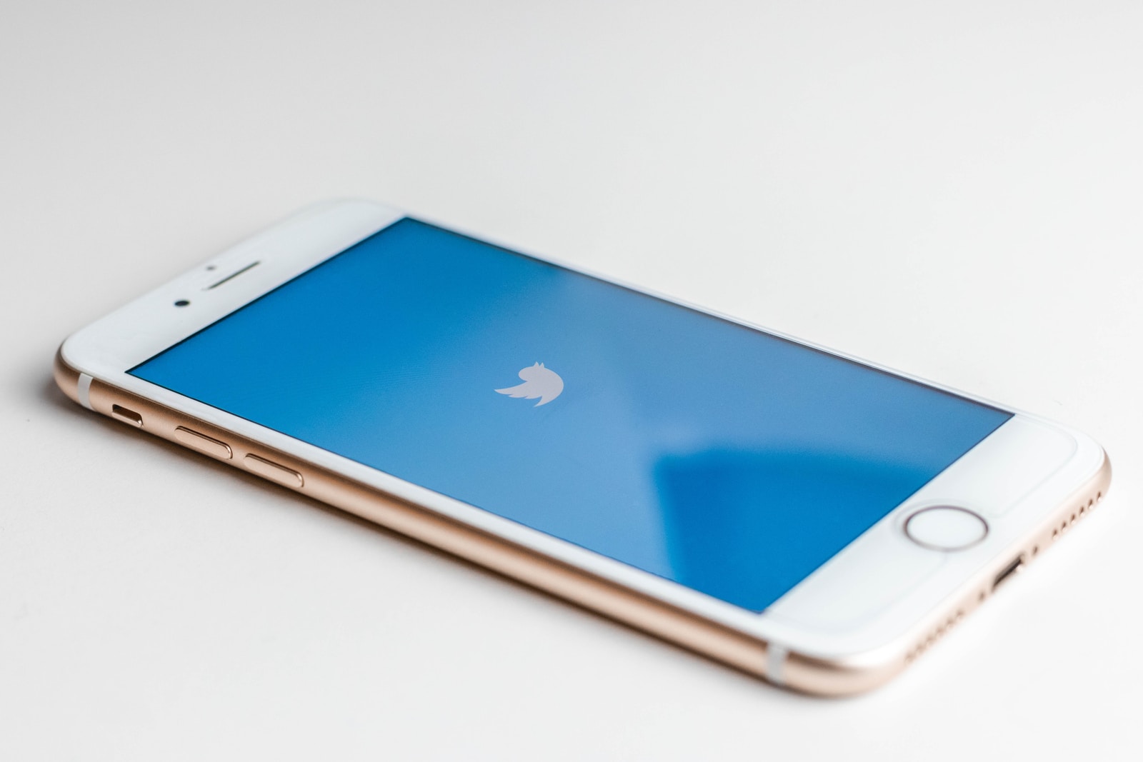 gold iPhone 6s with Twitter logo on screen