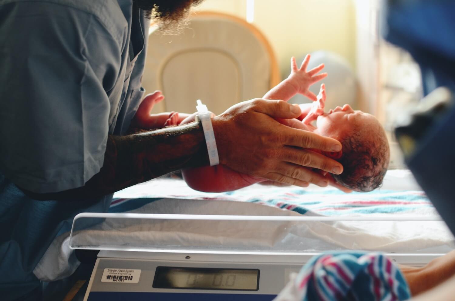 Parent holds newborn in hospital; Photo by Christian Bowen