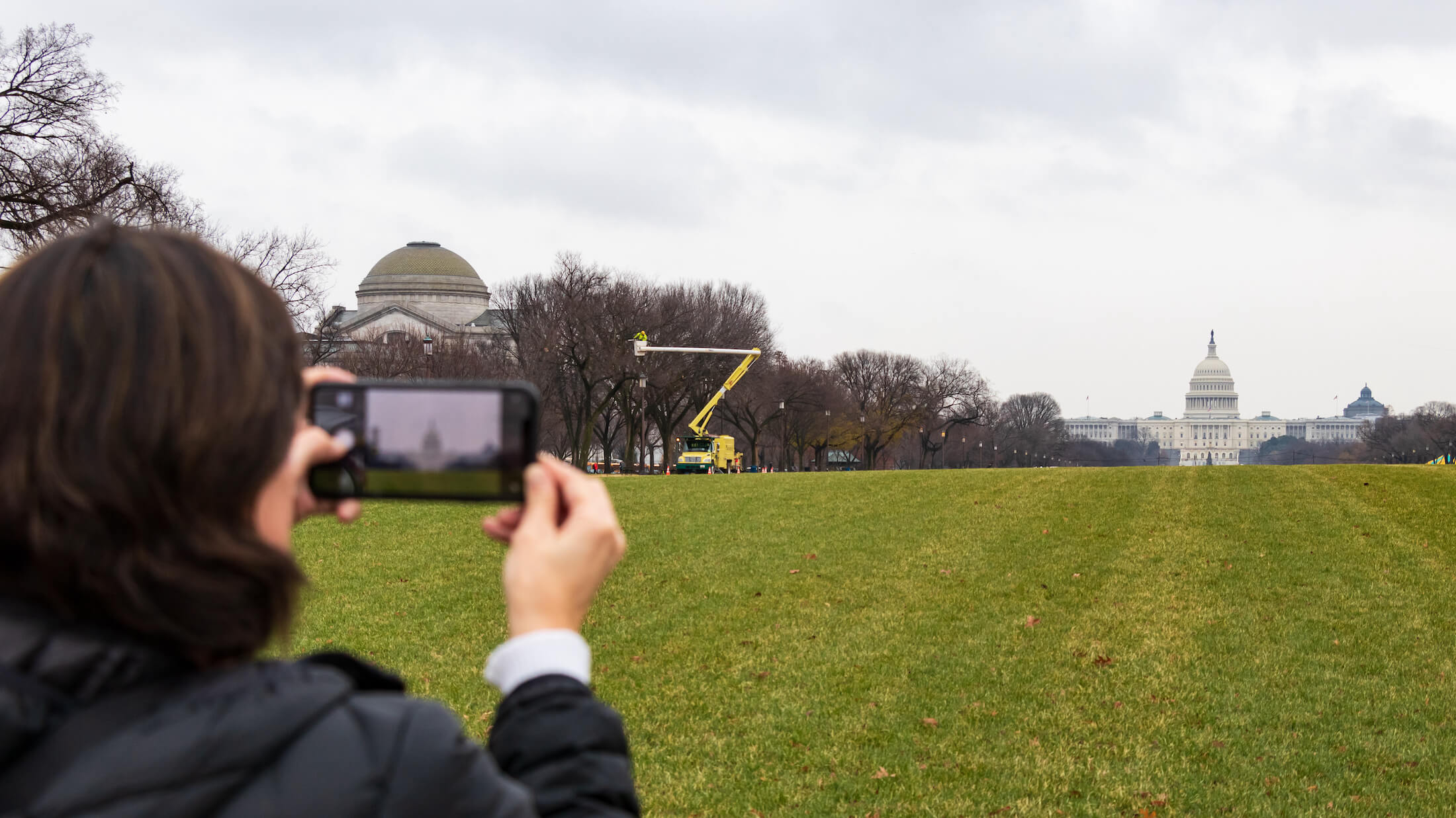 person taking picture of capitol with phone