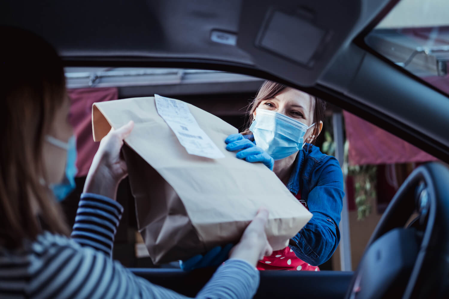 Worker in mask curbside pickup to driver