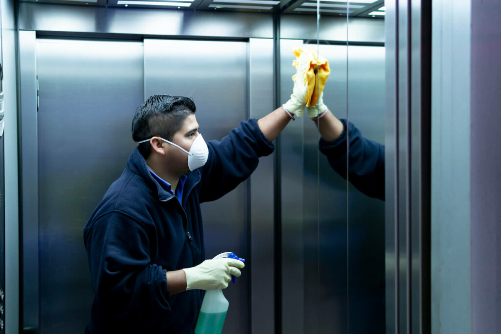 cleaning staff disinfecting elevator